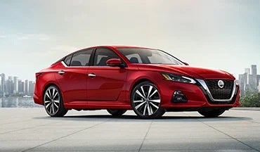 2023 Nissan Altima in red with city in background illustrating last year's 2022 model in South Colorado Springs Nissan in Colorado Springs CO